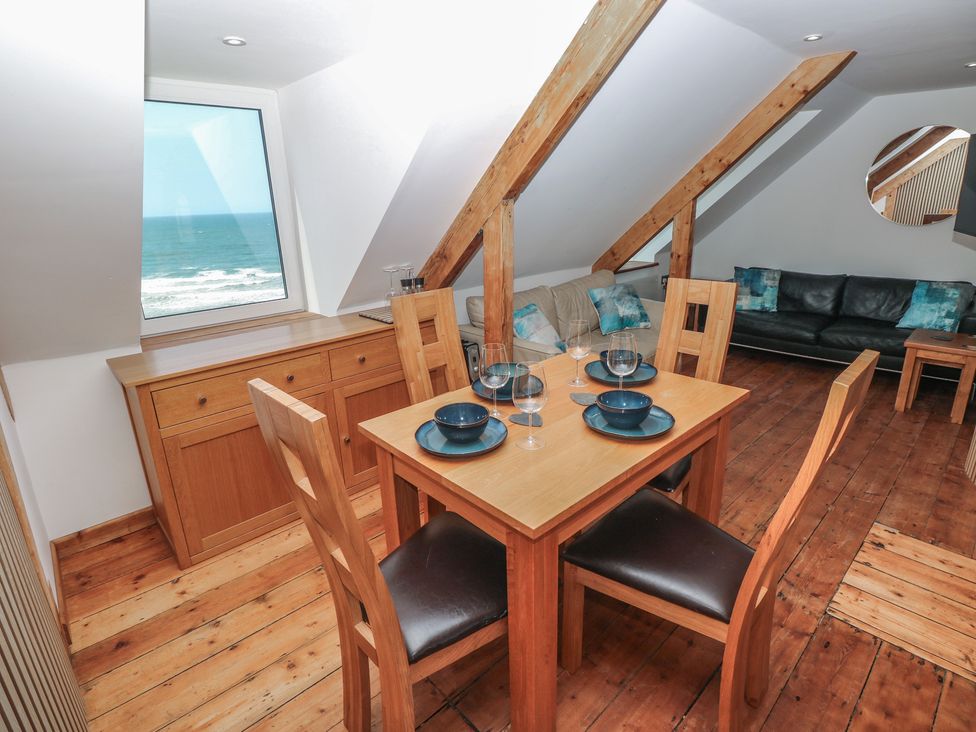 A dining area with a table and chairs at Awel Deg, Tresaith