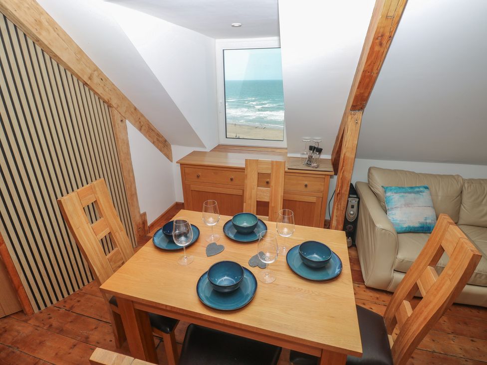 A dining room with a table and chairs at Awel Deg, Tresaith