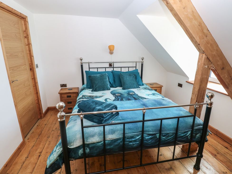 A bedroom with a bed and nightstand at Awel Deg, Tresaith