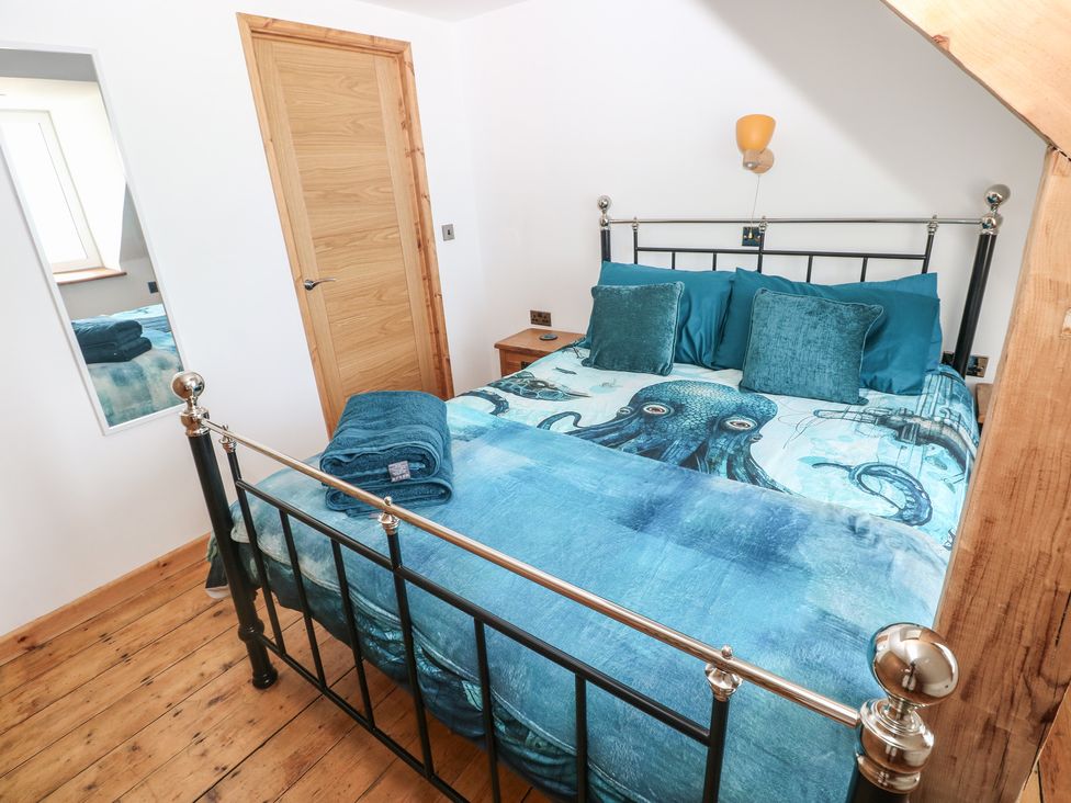 A bedroom with a bed and wooden furniture at Awel Deg, Tresaith