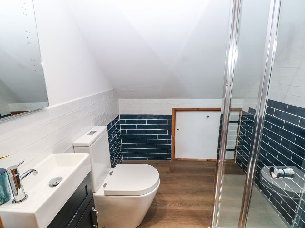A bathroom with a sink, toilet, and shower at Awel Deg, Tresaith