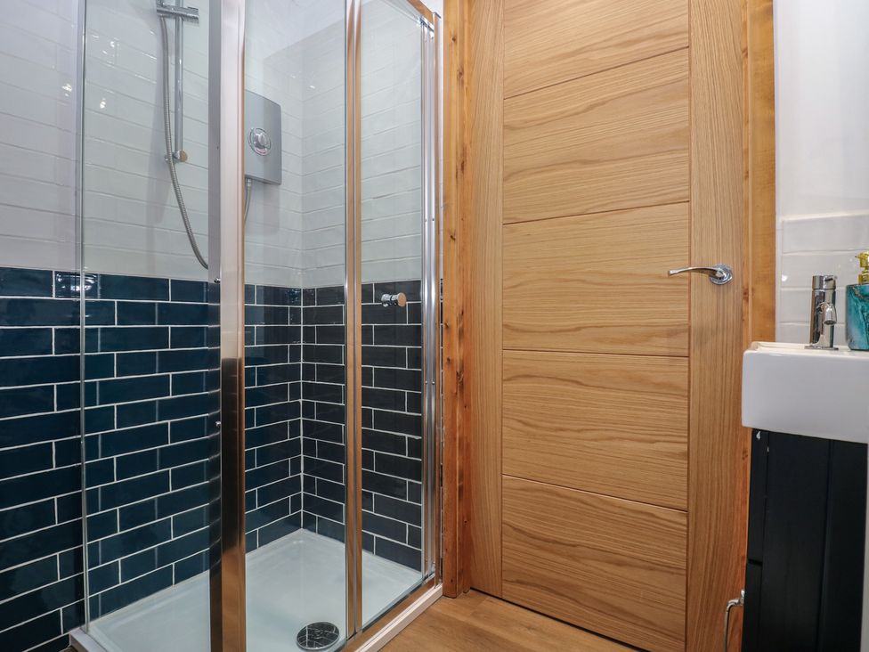 A shower unit and sink in a bathroom at Awel Deg, Tresaith