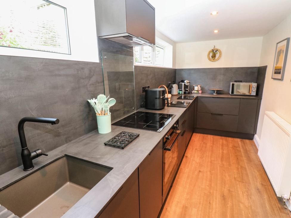 A kitchen with modern appliances and utensils at Ashtree Cottage