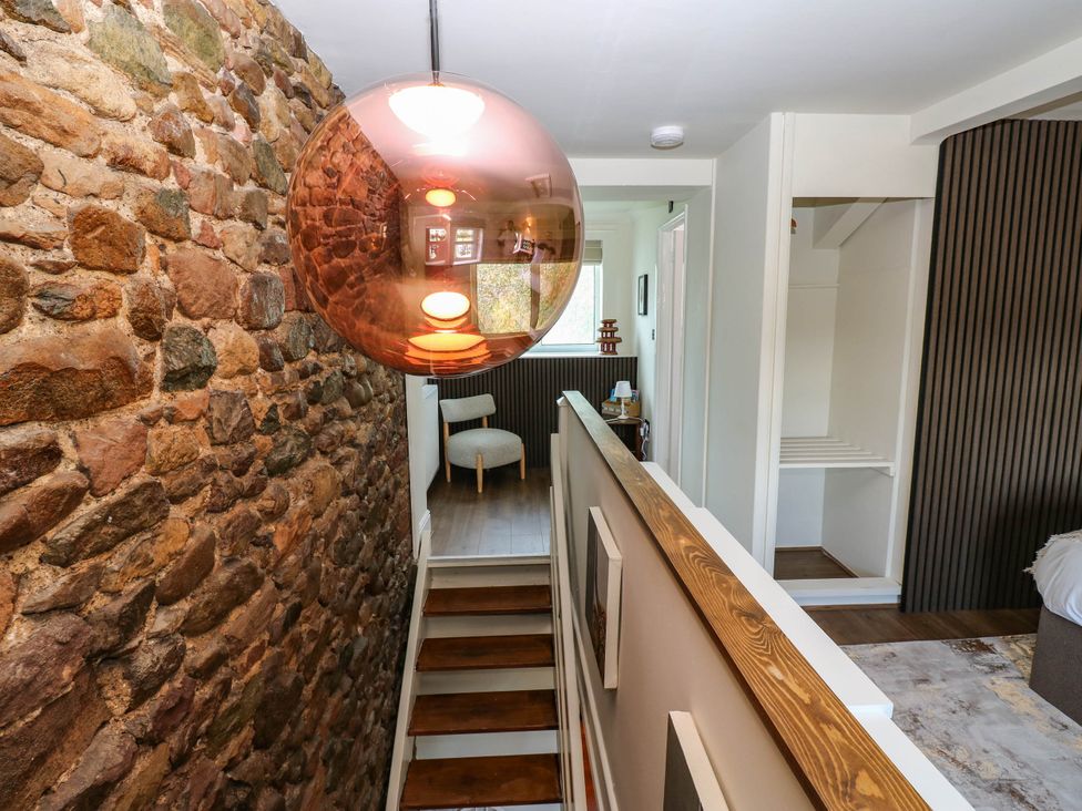 A hallway with stairs and a light fixture at Ashtree Cottage 