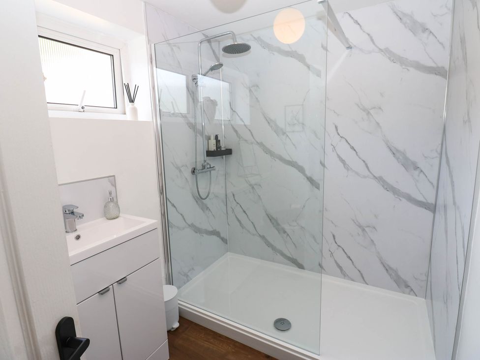 A shower area with a vanity and sink at Ashtree Cottage