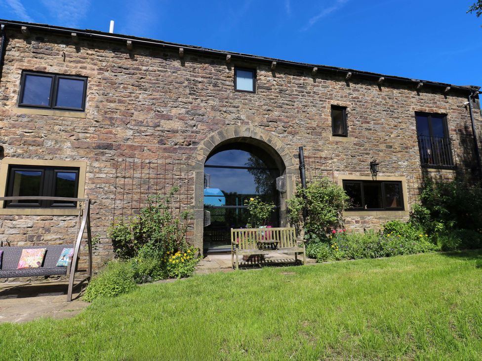 An outdoor view of a stone building with a garden at Bib Knowl Farm in Littleborough