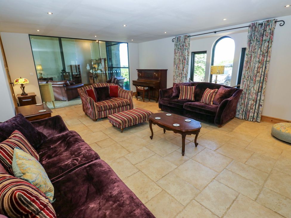 A living room with a piano and seating at Bib Knowl Farm in Littleborough