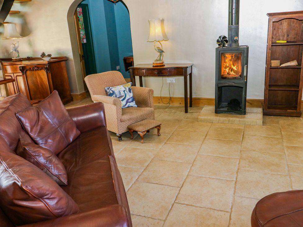 A living room with a wood stove and seating at Bib Knowl Farm in Littleborough