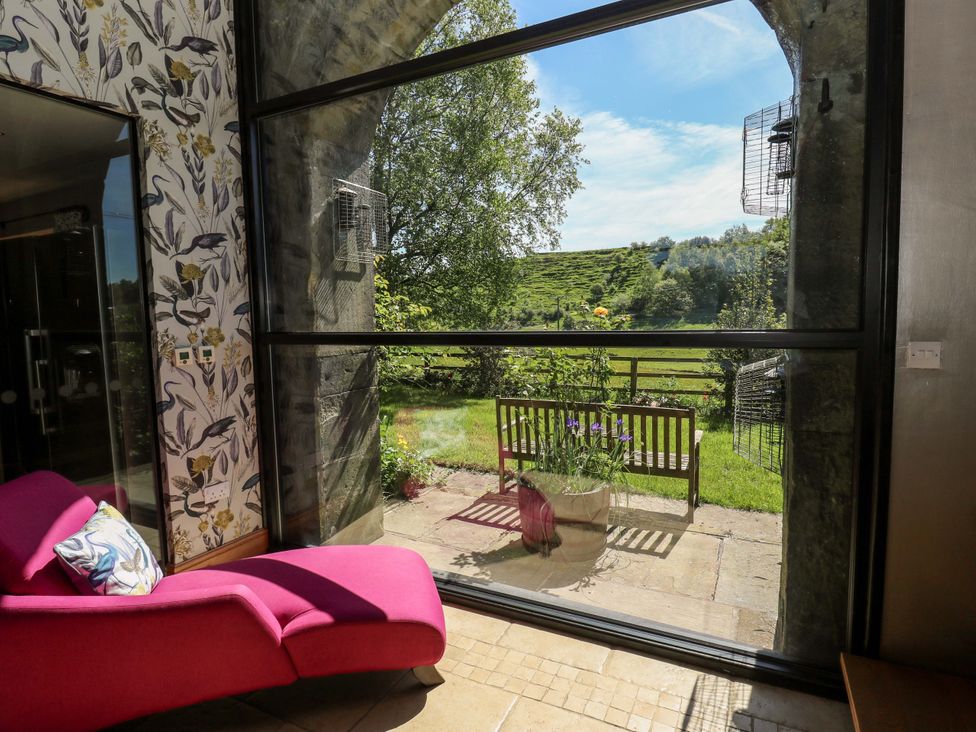 A conservatory with a view of the garden at Bib Knowl Farm in Littleborough