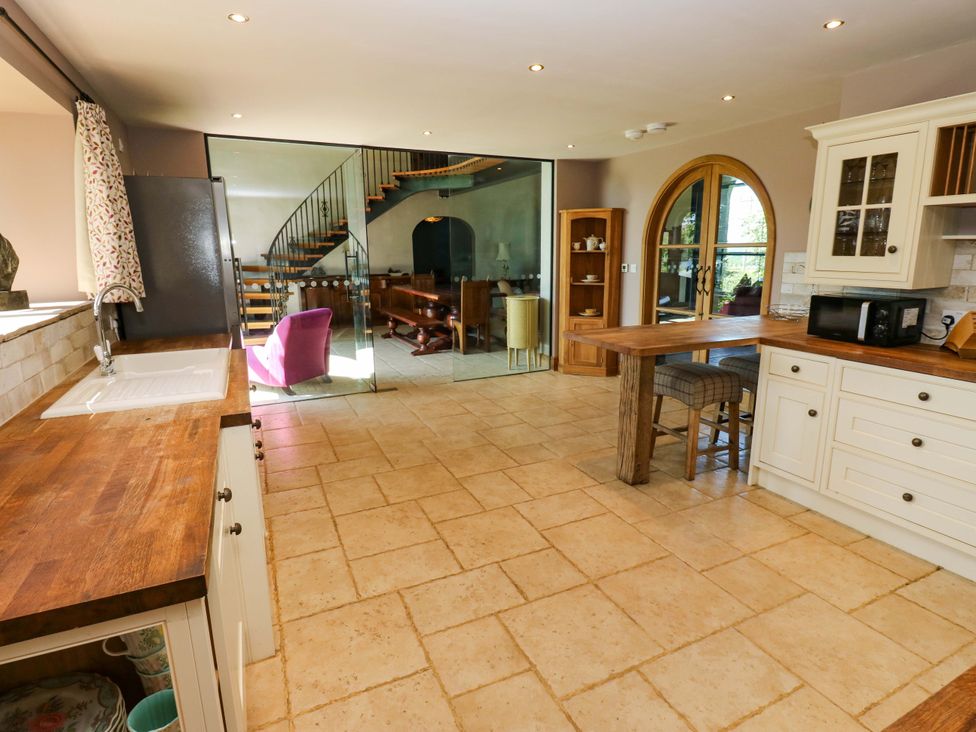 A kitchen with a sink and wooden countertop at Bib Knowl Farm in Littleborough