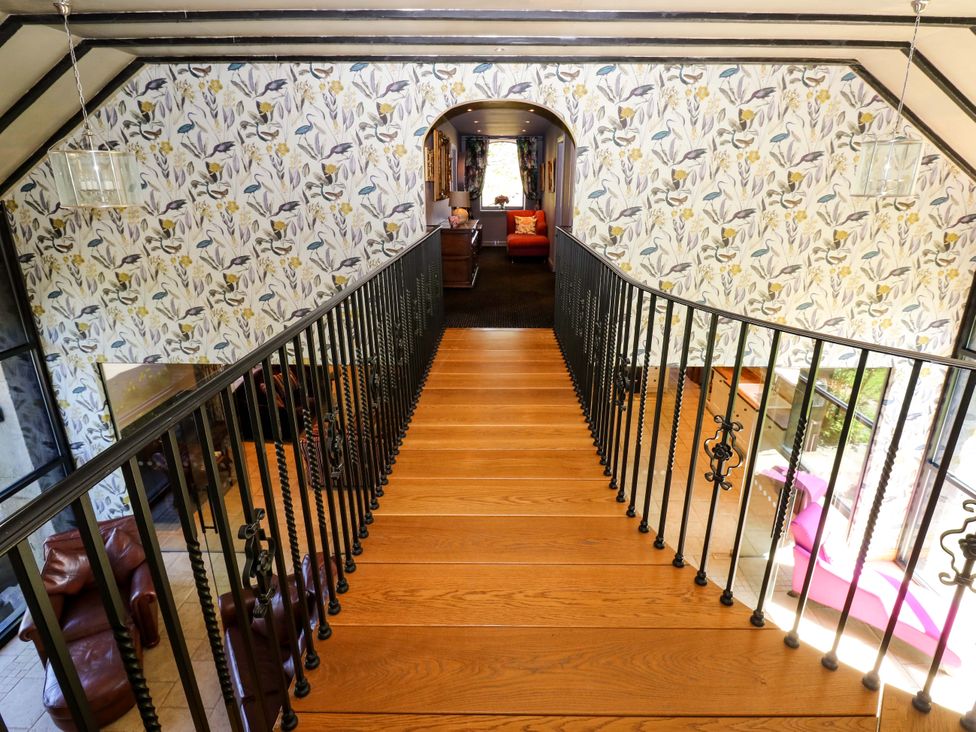 A staircase with railing in a hallway at Bib Knowl Farm in Littleborough