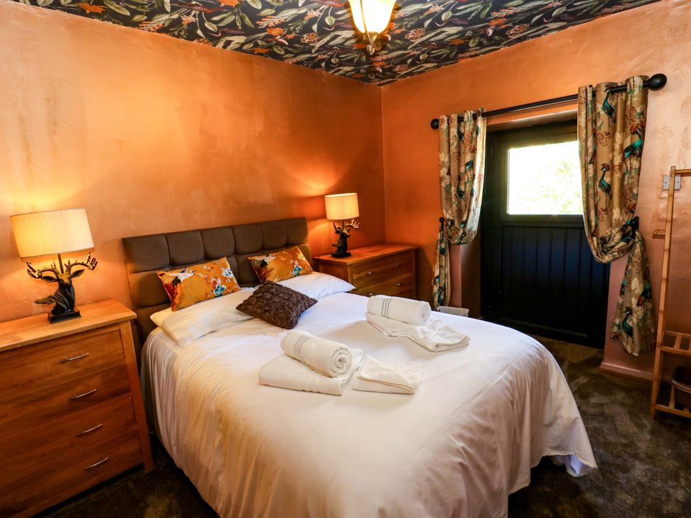 A bedroom with a bed and lamps at Bib Knowl Farm in Littleborough