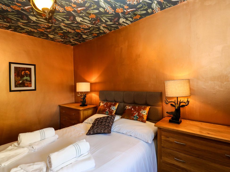 A bedroom with a bed and bedside lamps at Bib Knowl Farm in Littleborough