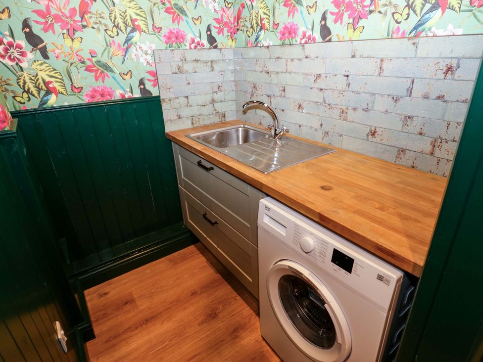 A laundry room with a sink and washing machine at Bib Knowl Farm in Littleborough