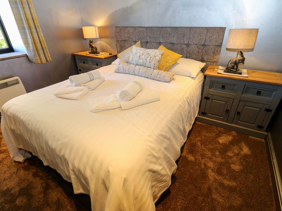 A bedroom with a bed and cabinets at Bib Knowl Farm in Littleborough