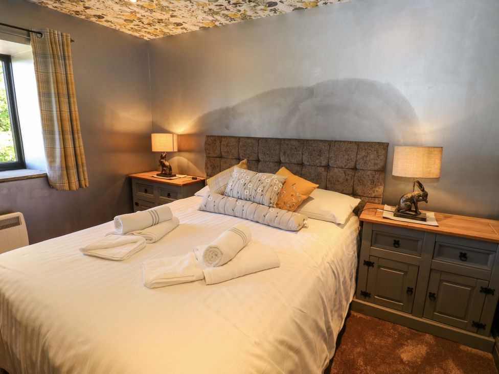 A bedroom with a bed and bedside table at Bib Knowl Farm in Littleborough