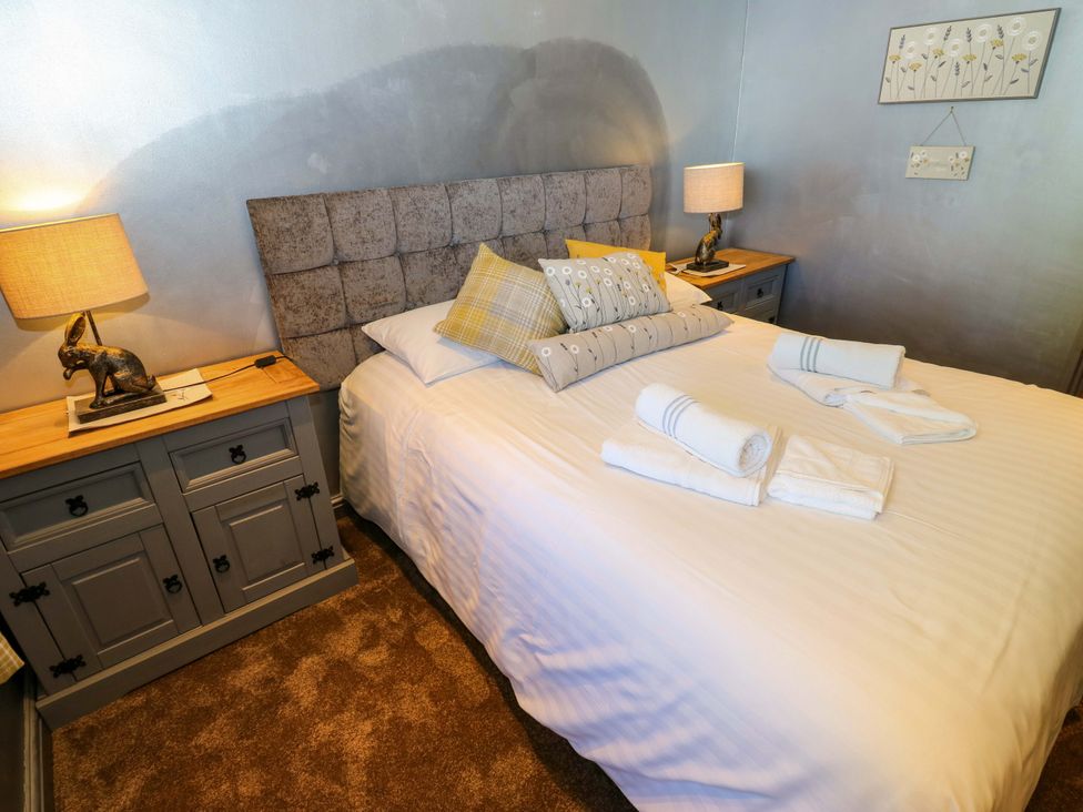 A bedroom with a bed and bedside tables at Bib Knowl Farm in Littleborough