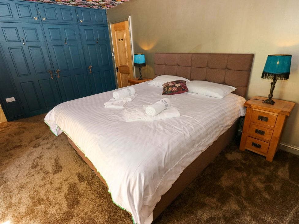 A bedroom with a large bed and wardrobe at Bib Knowl Farm in Littleborough