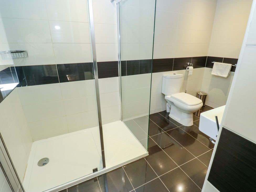 A bathroom with a shower, toilet, and sink at Bib Knowl Farm in Littleborough