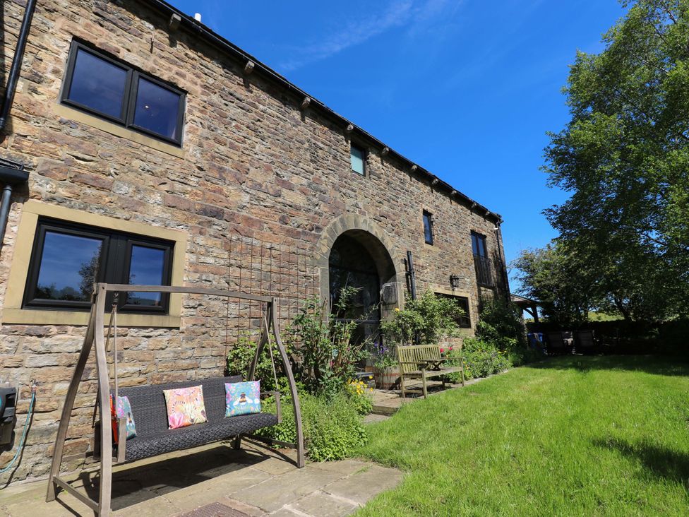A garden area with a swing and a bench at Bib Knowl Farm Littleborough