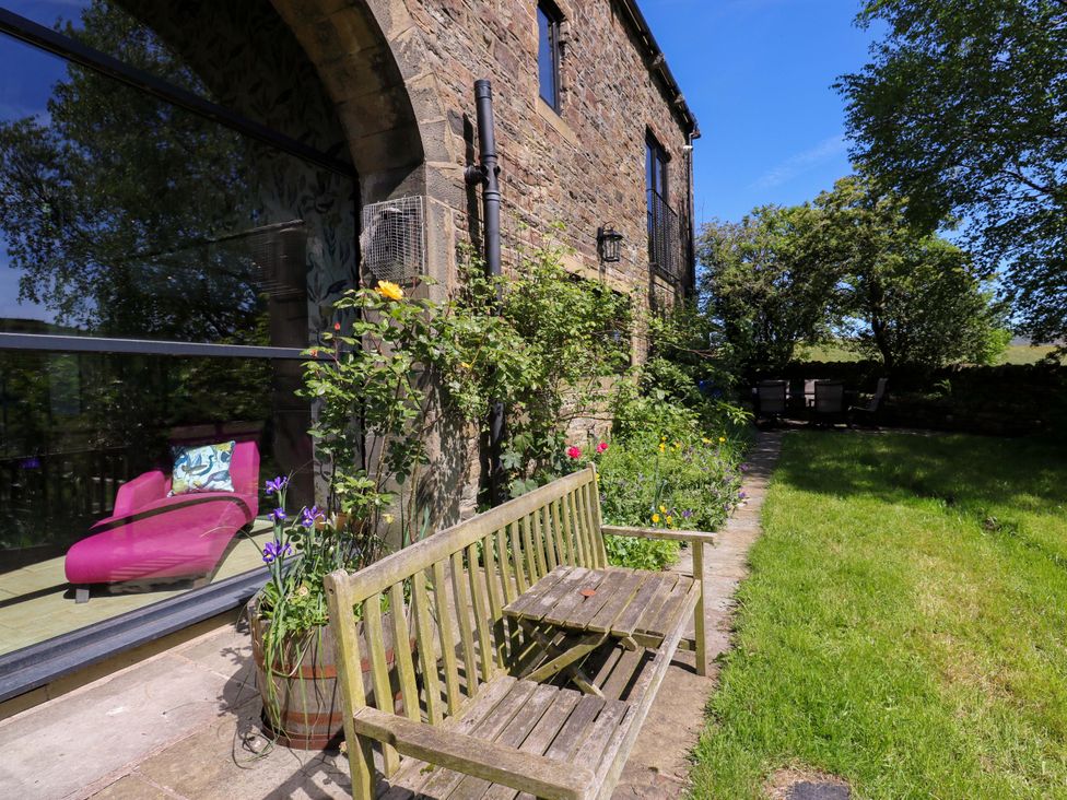 A garden with a bench and flowers at Bib Knowl Farm in Littleborough
