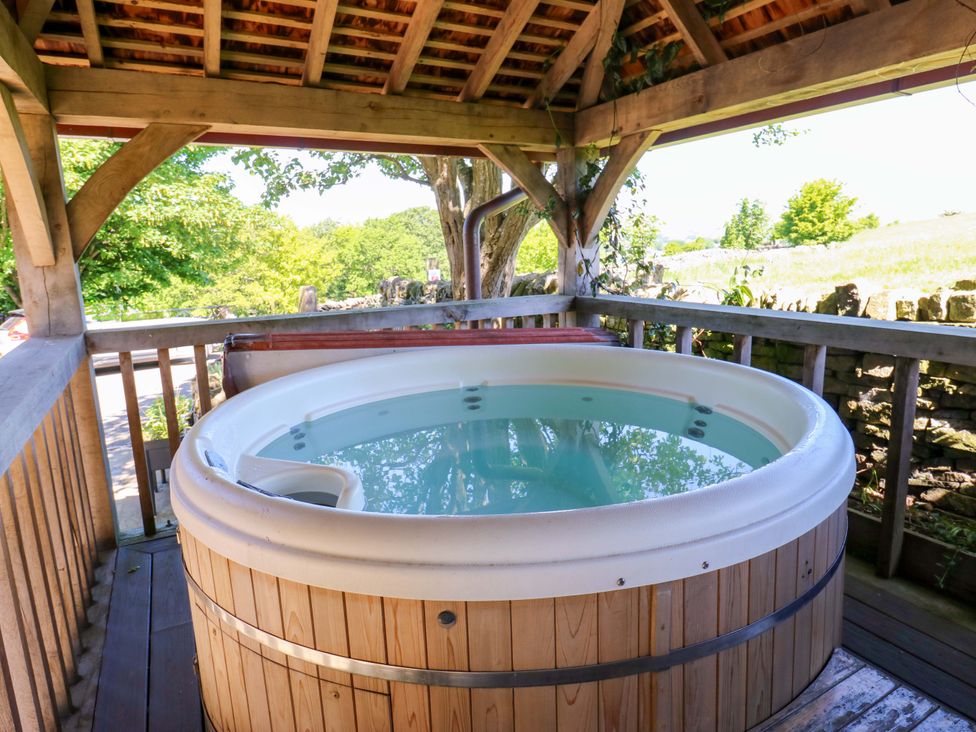 A hot tub on a wooden deck in an outdoor area at Bib Knowl Farm in Littleborough