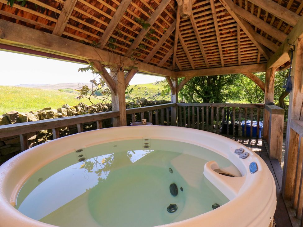 A hot tub under a wooden structure at Bib Knowl Farm in Littleborough