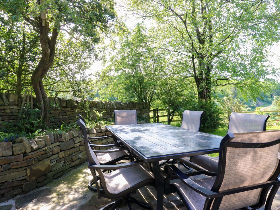 A garden with a table and chairs at Bib Knowl Farm, Littleborough