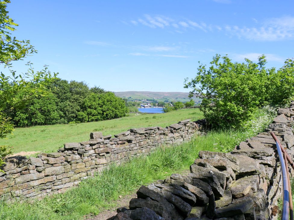 A view of a stone wall and green landscape at Bib Knowl Farm in Littleborough