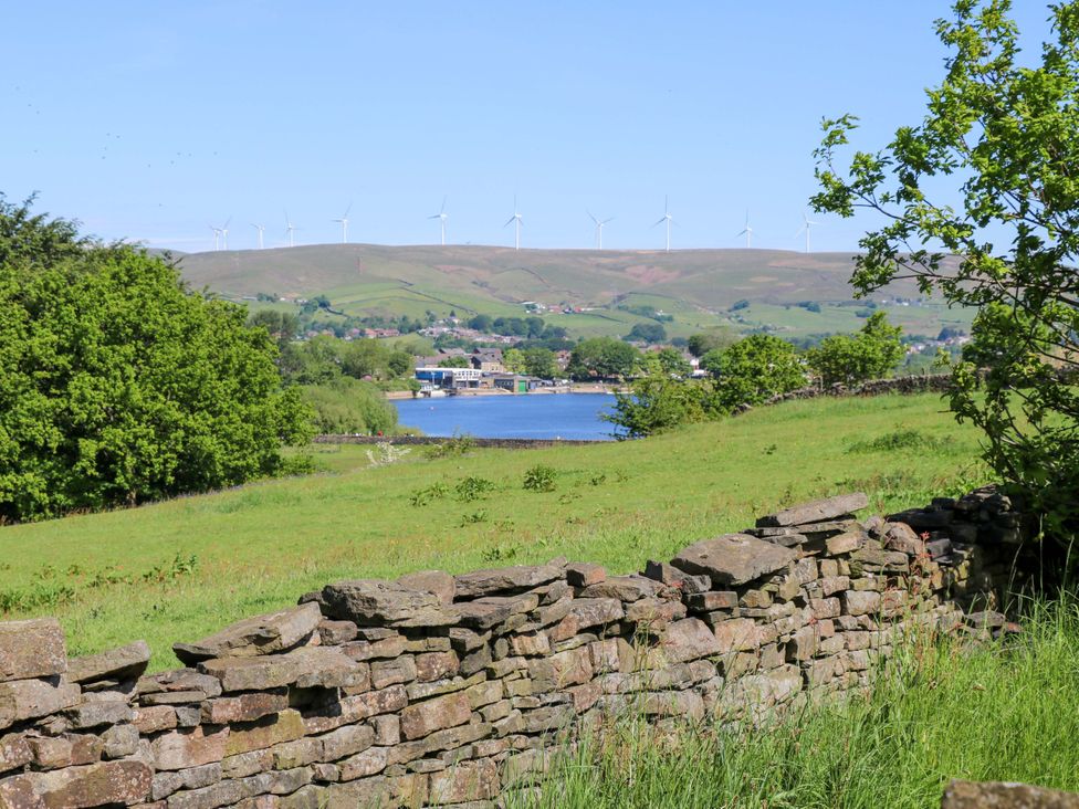 A view of hills and water with trees at Bib Knowl Farm in Littleborough