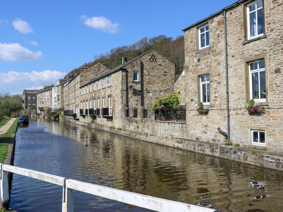 A canal with houses and greenery at Bib Knowl Farm in Littleborough