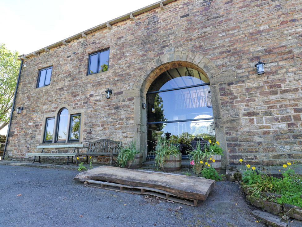 An entrance area with a stone facade and glass door at Bib Knowl Farm in Littleborough