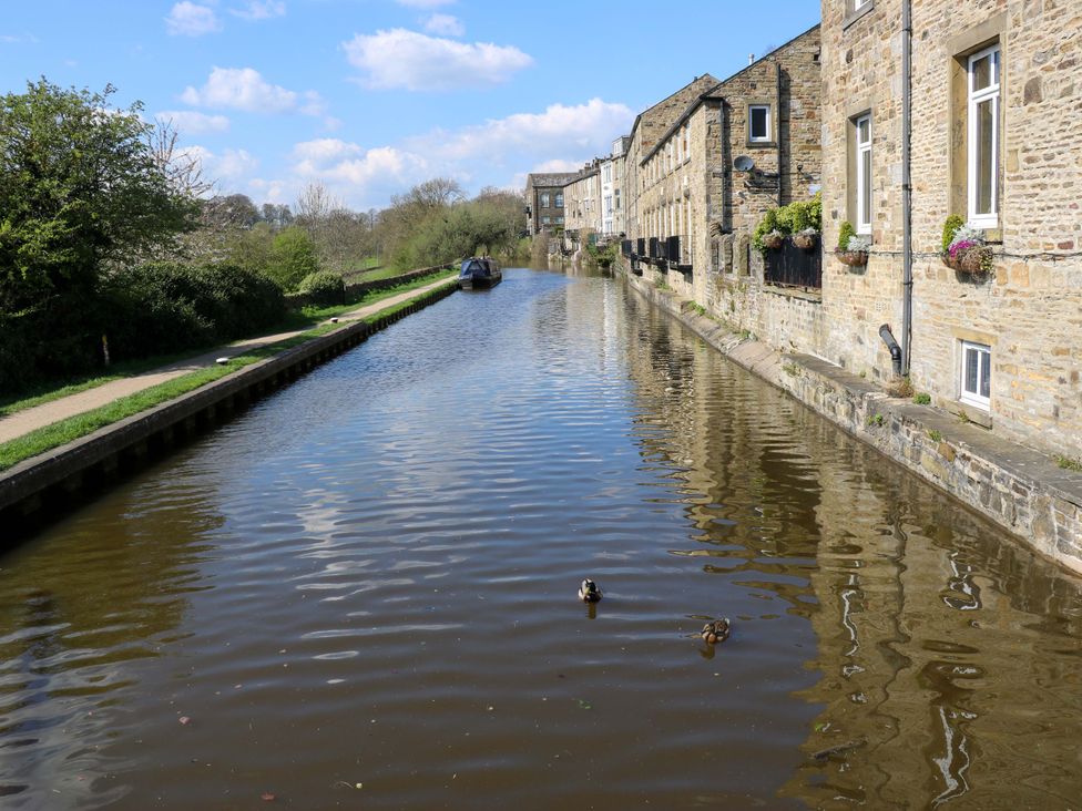 A canal with boats and buildings at Bib Knowl Farm in Littleborough