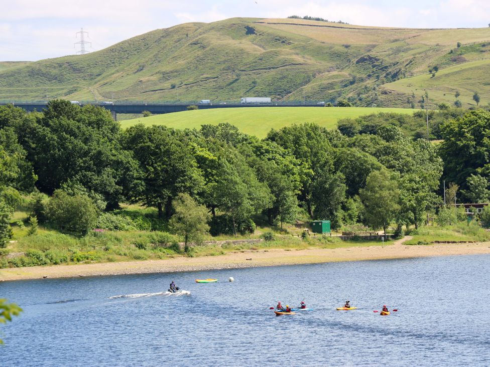 A lake with kayakers and a jet ski at Bib Knowl Farm Littleborough