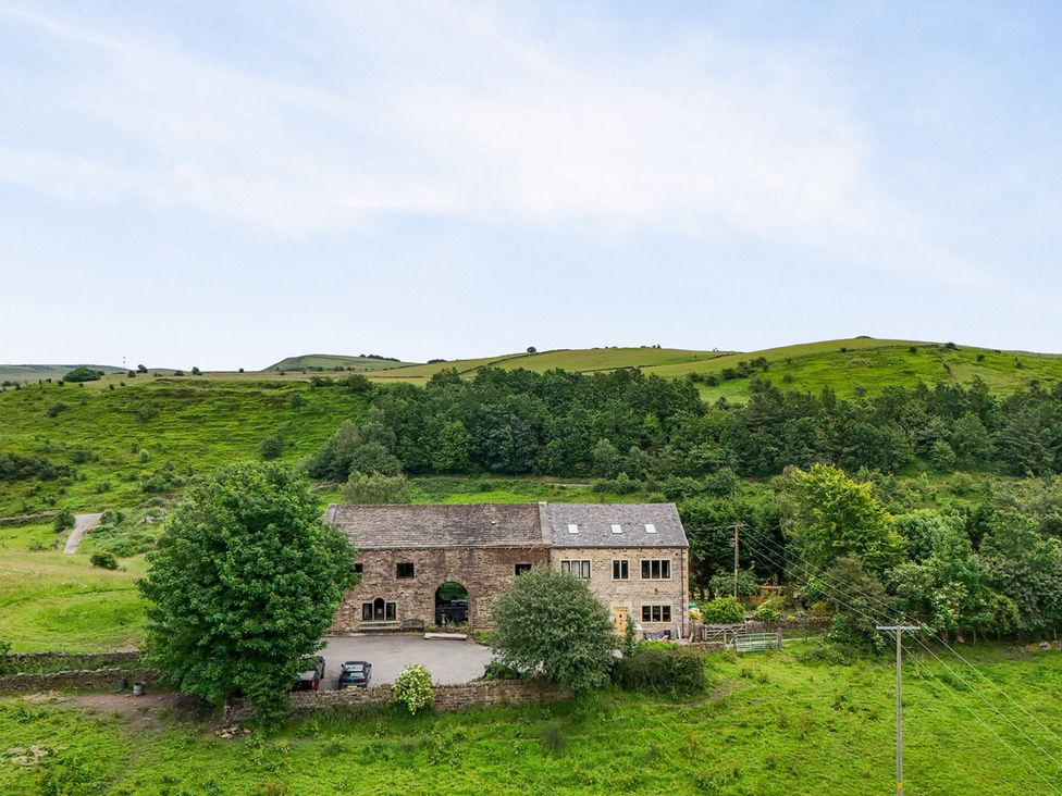 A house surrounded by trees and hills at Bib Knowl Farm in Littleborough