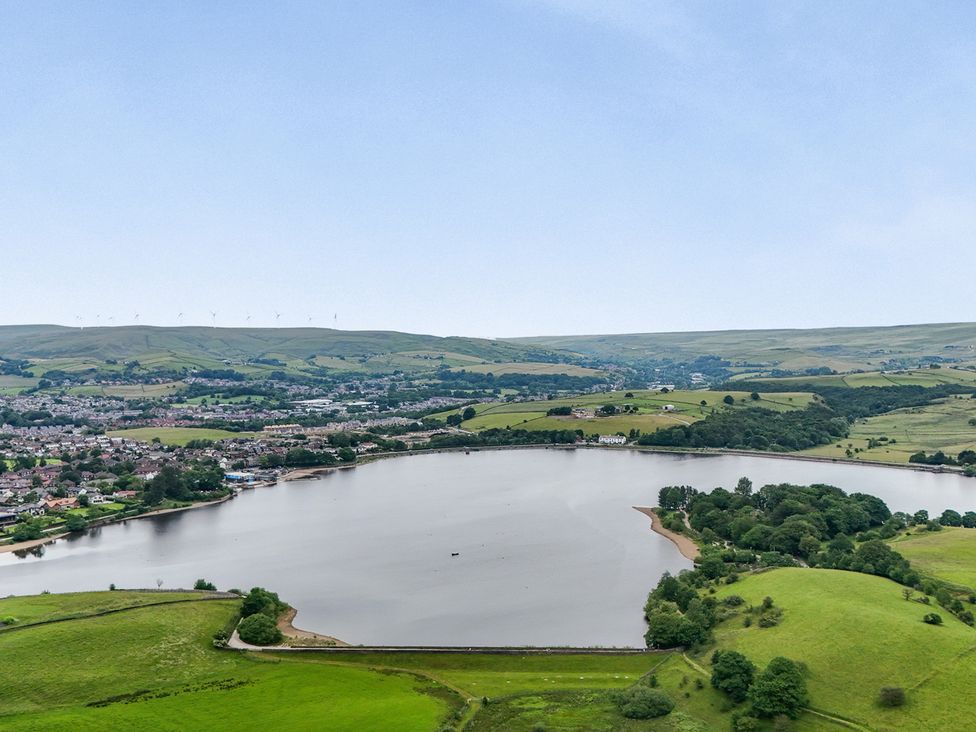 A landscape view of a lake surrounded by hills and a town at Bib Knowl Farm Littleborough