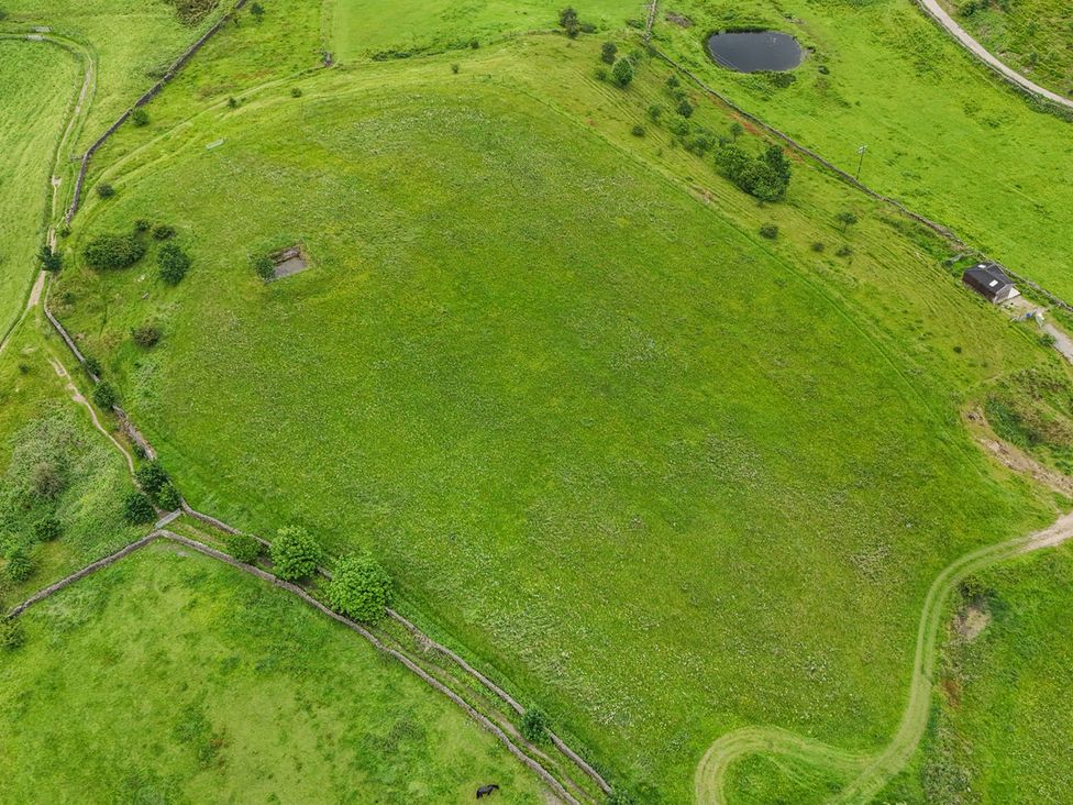 An outdoor field with grass and a pond at Bib Knowl Farm in Littleborough