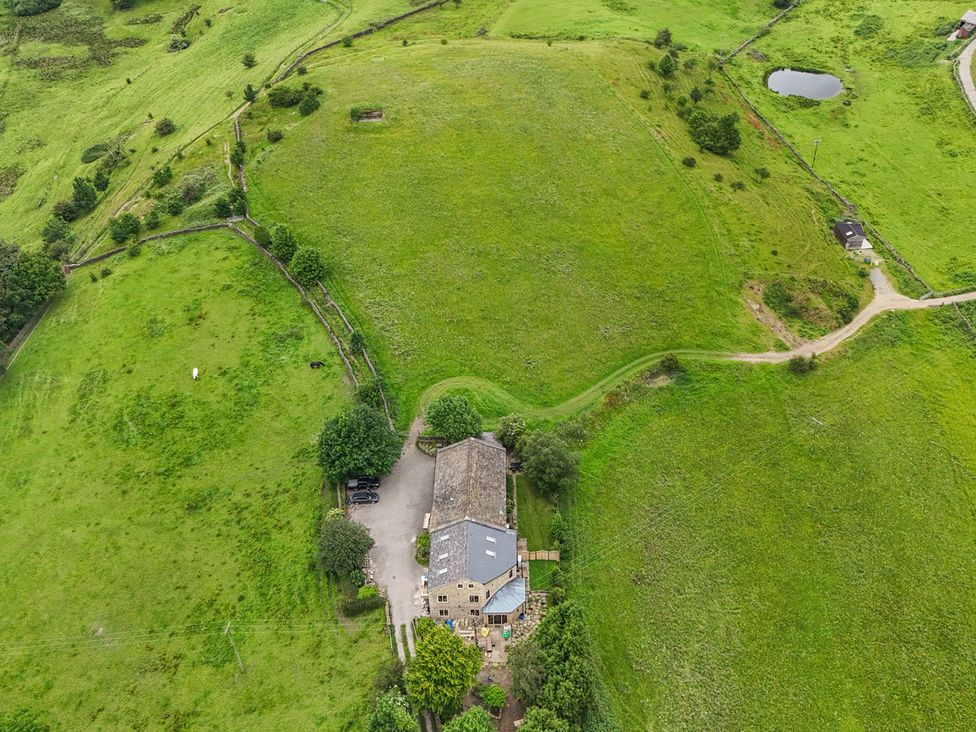 An aerial view of a farmhouse surrounded by fields at Bib Knowl Farm in Littleborough