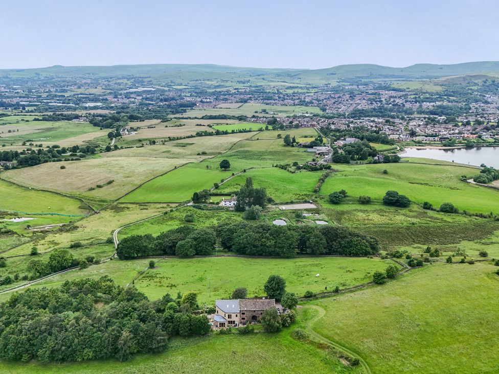 A view of the landscape with fields and a house at Bib Knowl Farm in Littleborough