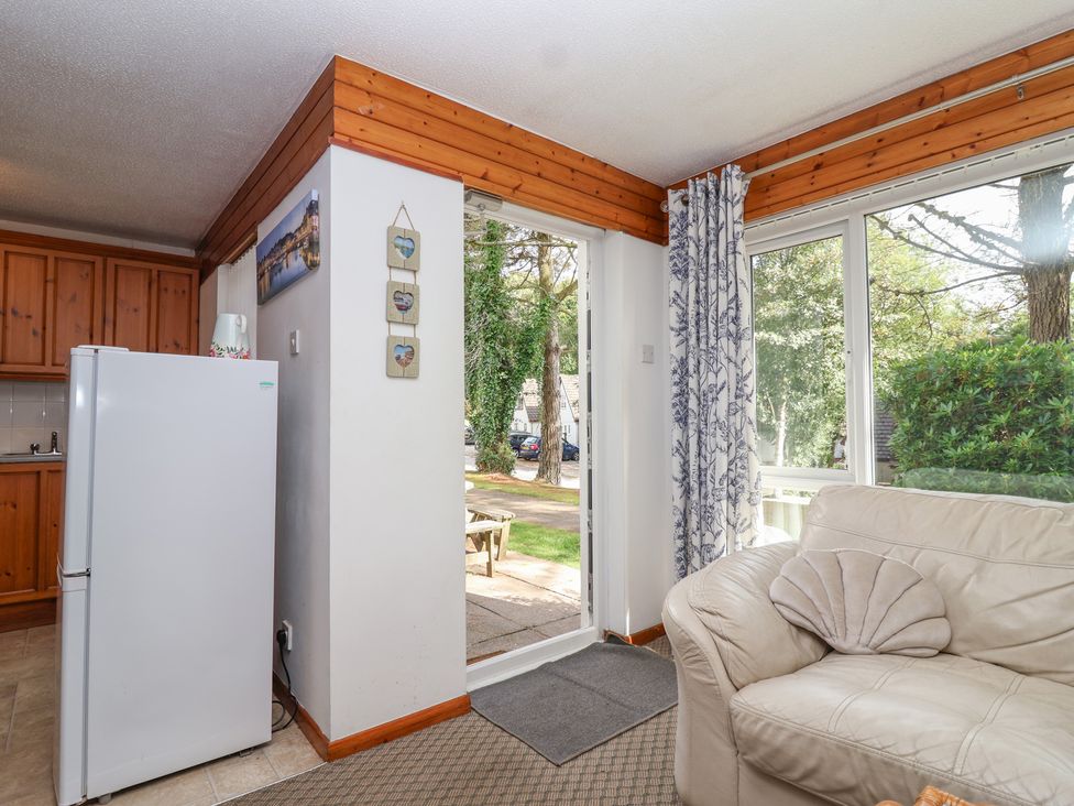 A living room with a refrigerator and a couch at Manorcombe 1 near Honicombe Park