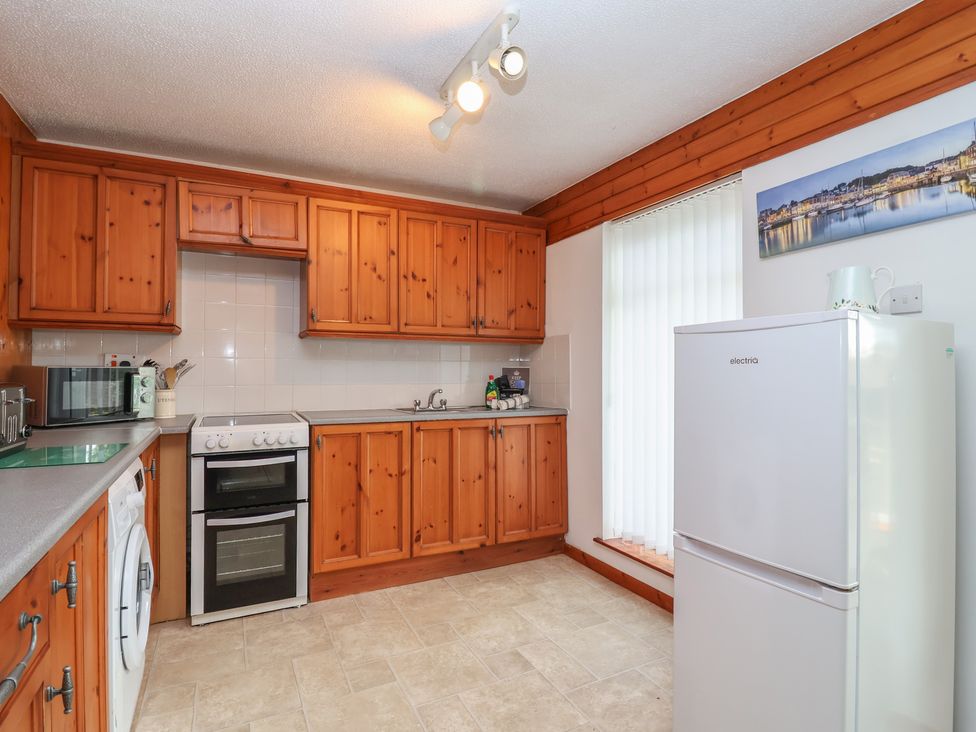 A kitchen with cabinets, fridge, and oven at Manorcombe 1 Honicombe Park near Gunnislake