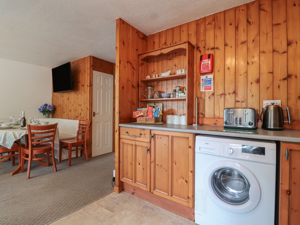 A kitchen with a washing machine and a dining area at Manorcombe 1 Honicombe Park near Gunnislake