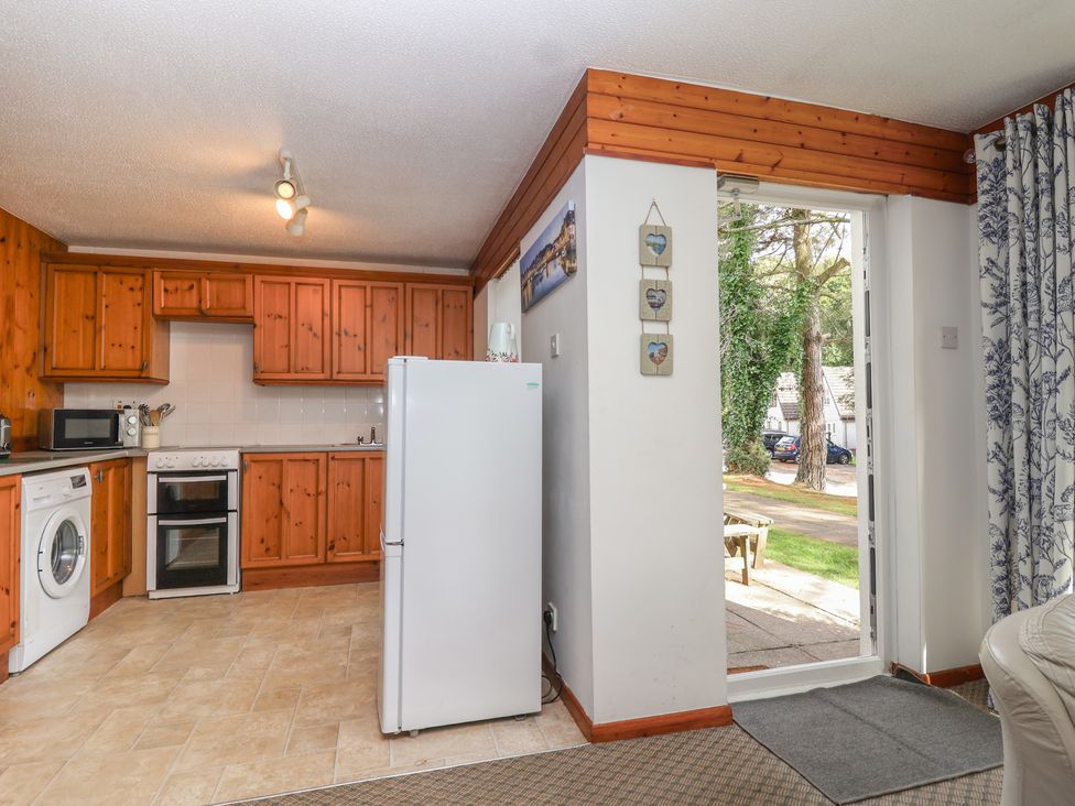 A kitchen with appliances and a door leading outside at Manorcombe 1 Honicombe Park near Gunnislake