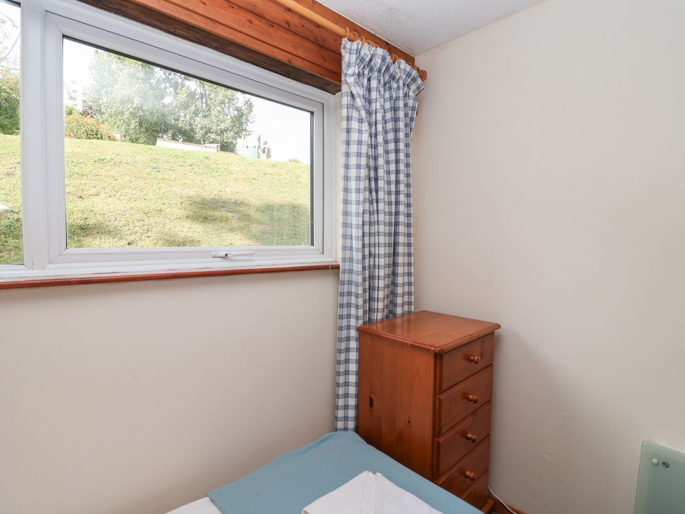 A bedroom with a dresser and window at Manorcombe 1 Honicombe Park near Gunnislake