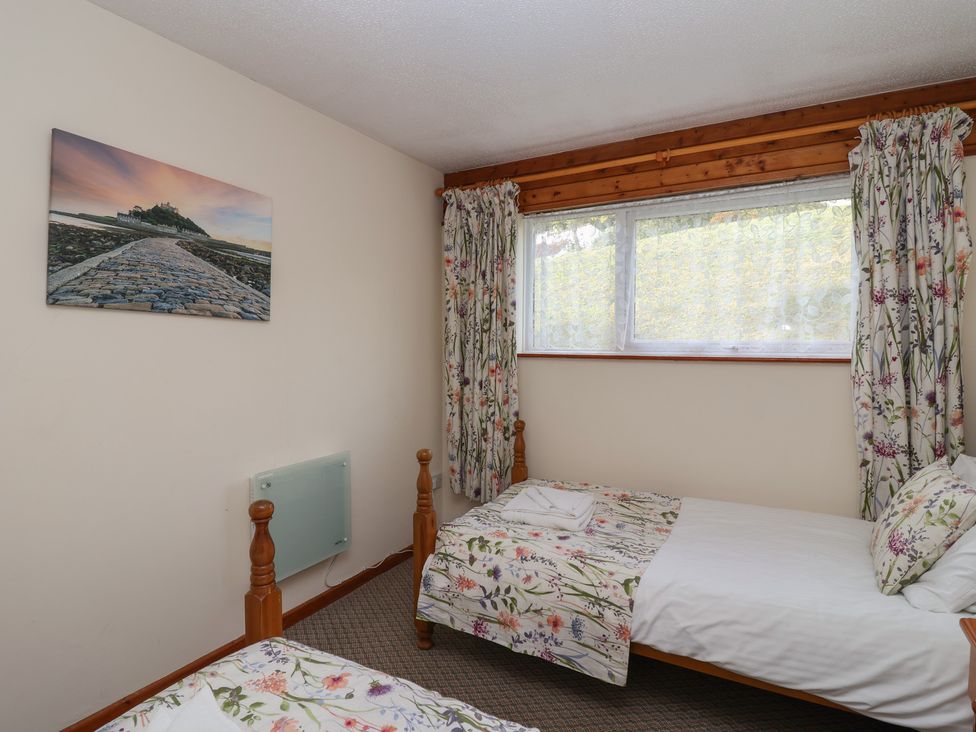 A bedroom with two single beds and a window at Manorcombe 1 Honicombe Park near Gunnislake