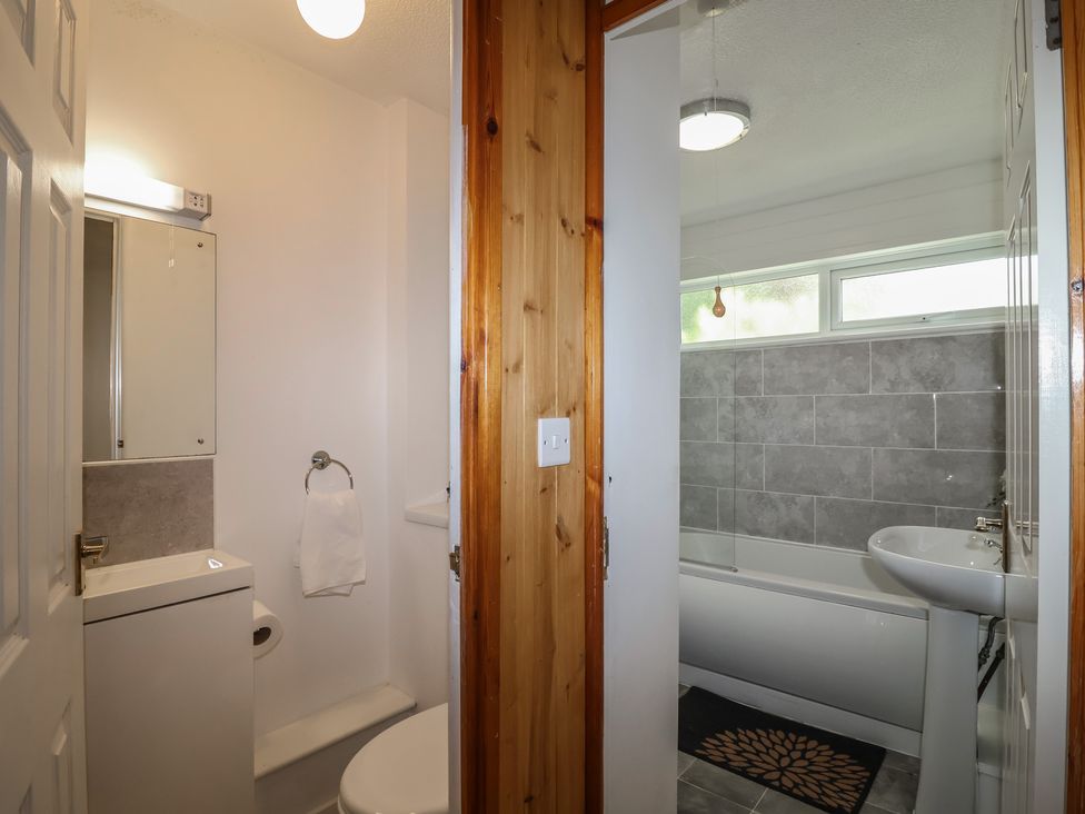 A bathroom with a toilet, sink, and bathtub at Manorcombe 1 Honicombe Park near Gunnislake