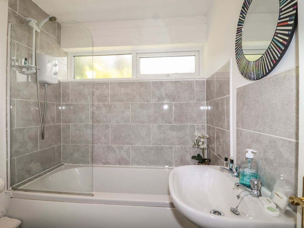 A bathroom with a shower and bathtub at Manorcombe 1 Honicombe Park near Gunnislake