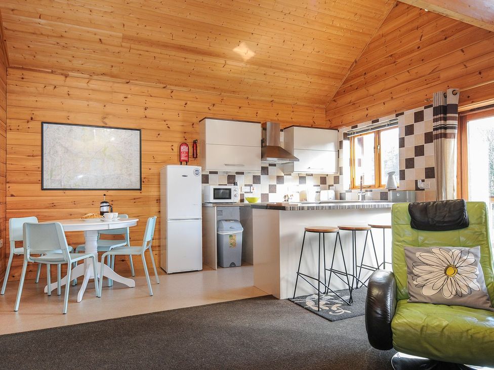 A kitchen with a dining table and appliances at Trevano St Breward