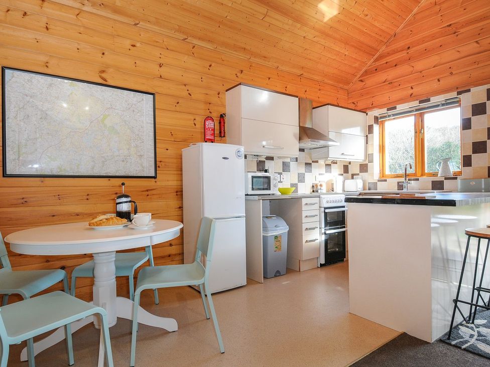 A kitchen with wooden walls and appliances at Trevano in St Breward