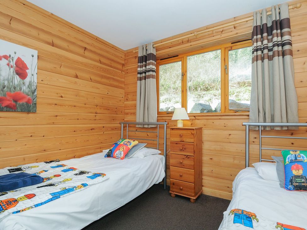 A bedroom with two beds and a wooden nightstand at Trevano in St Breward